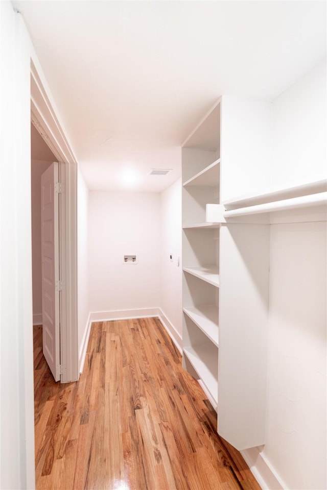 walk in closet with light wood-type flooring