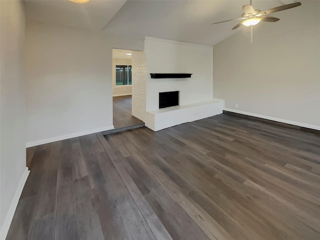 unfurnished living room with lofted ceiling, dark wood-type flooring, a fireplace, and ceiling fan