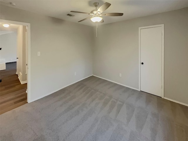 carpeted empty room featuring ceiling fan