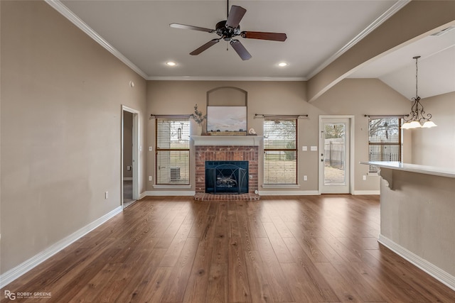 unfurnished living room featuring dark wood-type flooring, a healthy amount of sunlight, and a brick fireplace