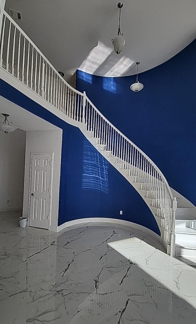 stairway featuring a towering ceiling