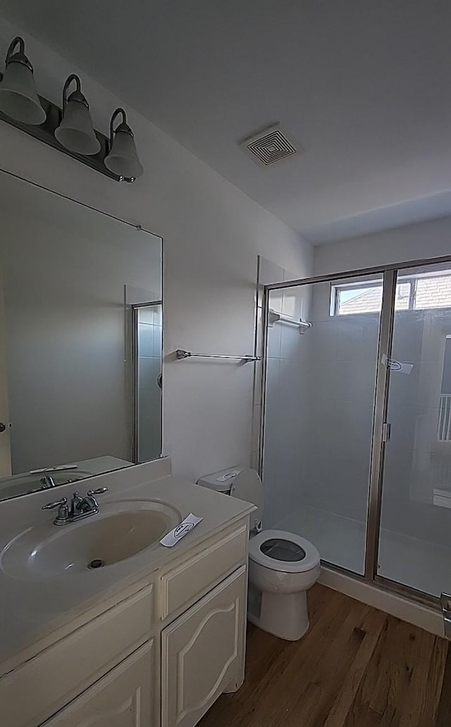 bathroom with vanity, wood-type flooring, toilet, and walk in shower