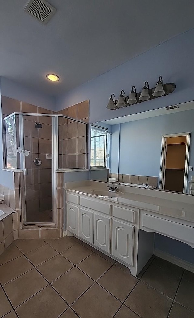 bathroom featuring tile patterned flooring, vanity, and plus walk in shower