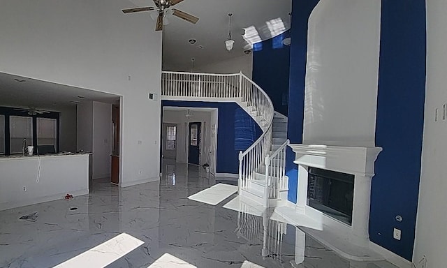 unfurnished living room with a towering ceiling and ceiling fan