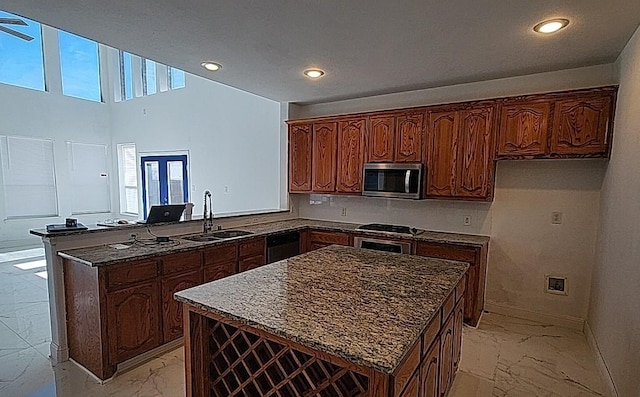 kitchen featuring sink, kitchen peninsula, dishwasher, and a kitchen island