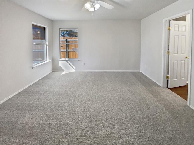 carpeted spare room featuring ceiling fan