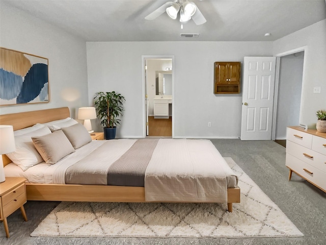 bedroom with carpet floors, connected bathroom, and ceiling fan