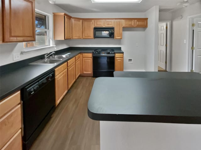 kitchen with sink, wood-type flooring, and black appliances