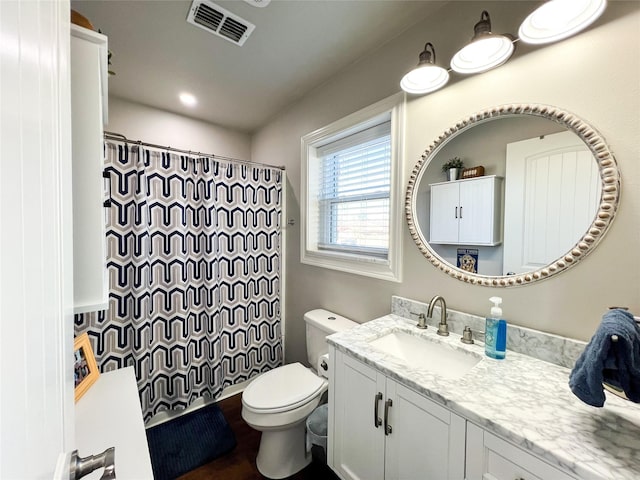 bathroom featuring vanity, toilet, and walk in shower