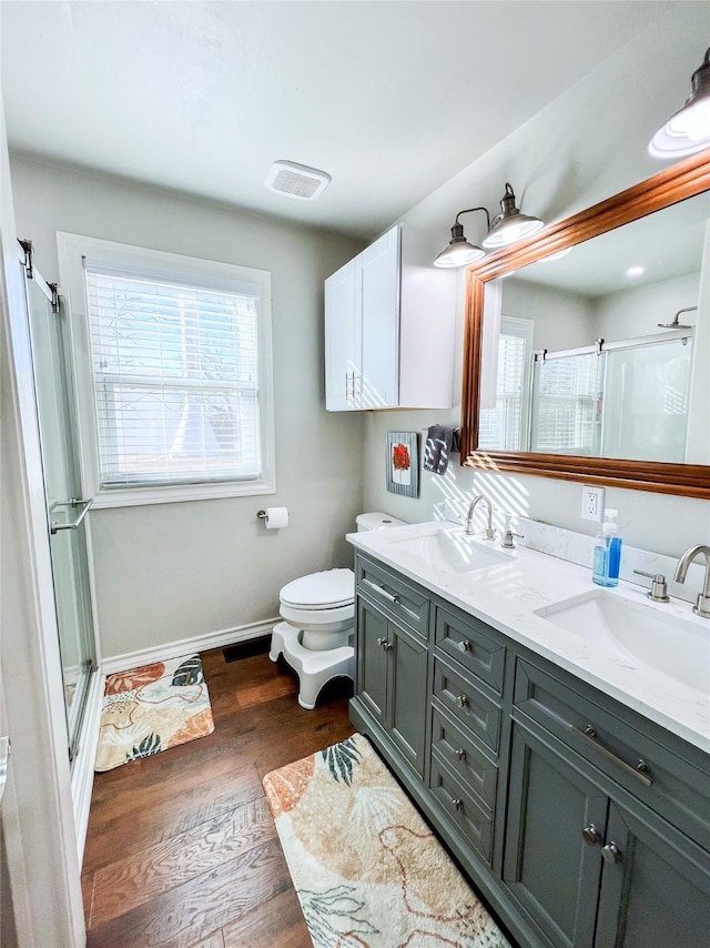 bathroom with vanity, wood-type flooring, a shower with shower door, and toilet