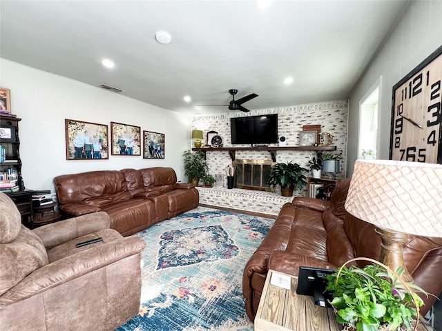 living room featuring a brick fireplace and ceiling fan