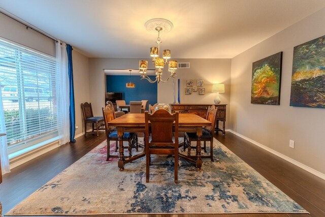 dining area with dark hardwood / wood-style flooring and an inviting chandelier