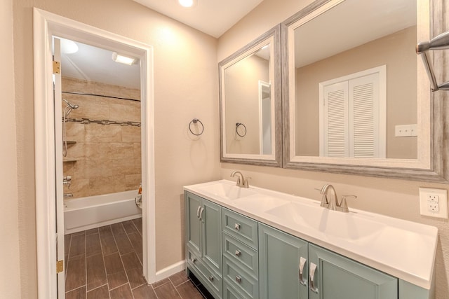 bathroom featuring tiled shower / bath combo and vanity