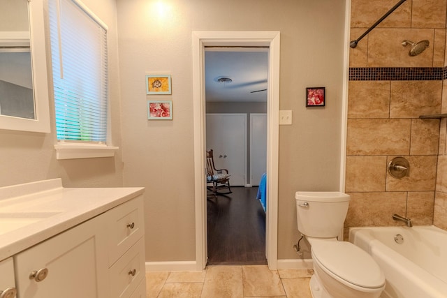 full bathroom featuring tiled shower / bath, vanity, and toilet