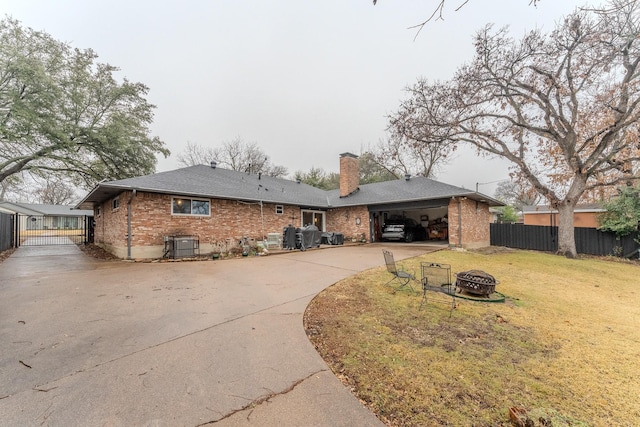 view of front of house with a garage, a front lawn, and a fire pit