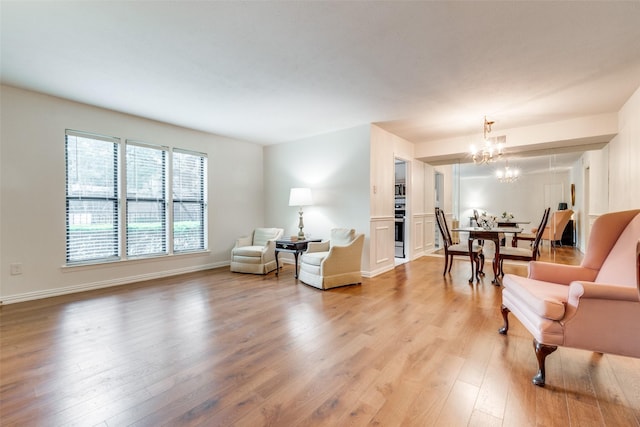 sitting room featuring an inviting chandelier and light hardwood / wood-style flooring