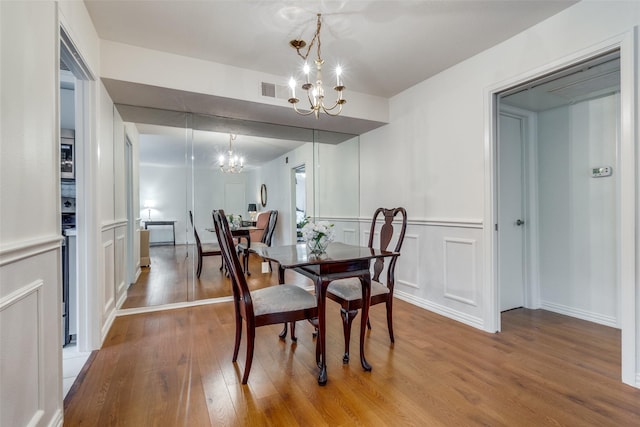 dining area featuring a notable chandelier and wood-type flooring