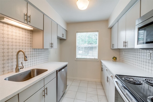 kitchen featuring stainless steel appliances, tasteful backsplash, sink, and white cabinets