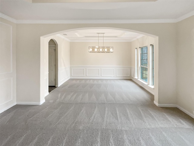 spare room featuring crown molding, carpet, and a chandelier