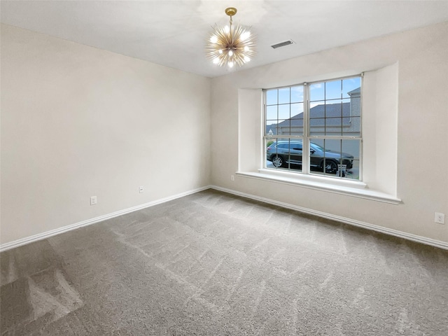 carpeted empty room with a chandelier