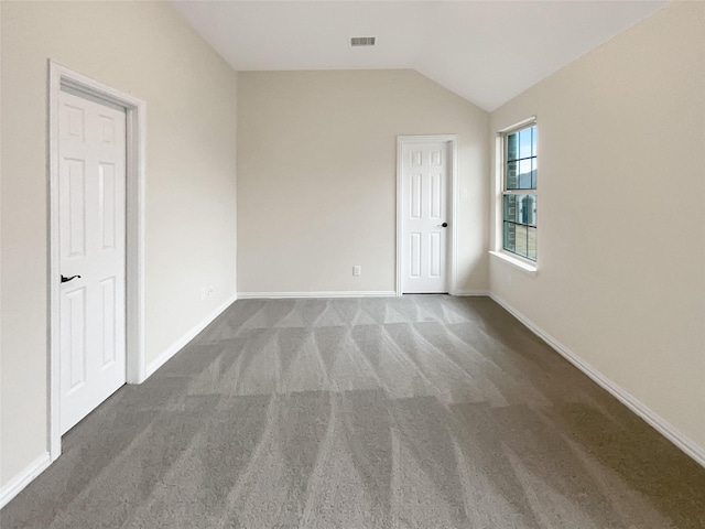 spare room featuring vaulted ceiling and carpet