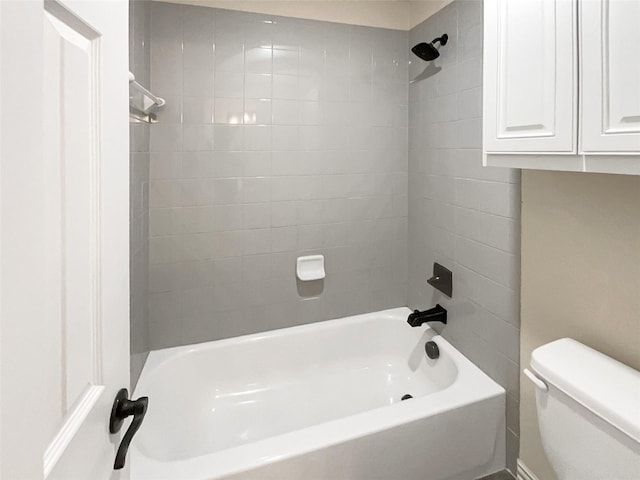 bathroom featuring tiled shower / bath and toilet