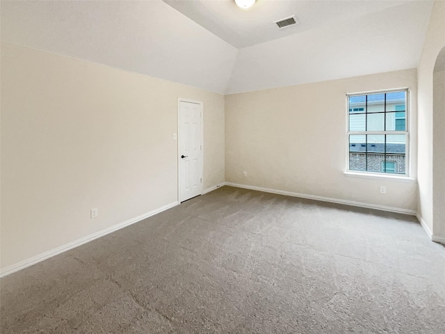 carpeted empty room with lofted ceiling