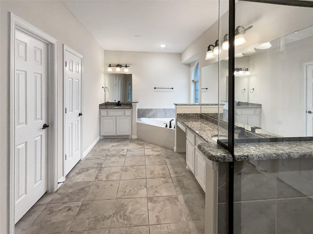 bathroom featuring vanity and a tub to relax in