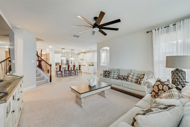 carpeted living room with ceiling fan