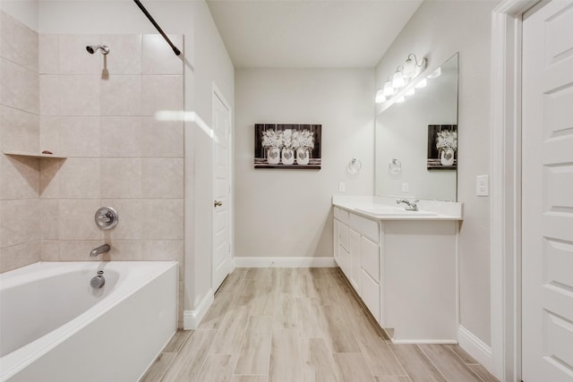 bathroom with tiled shower / bath, wood-type flooring, and vanity