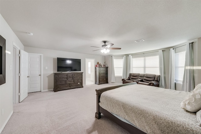 carpeted bedroom with multiple windows, ceiling fan, and a textured ceiling