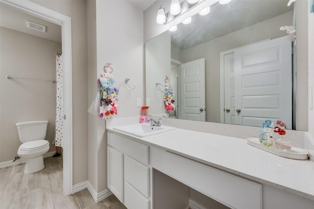 bathroom featuring hardwood / wood-style flooring, vanity, and toilet