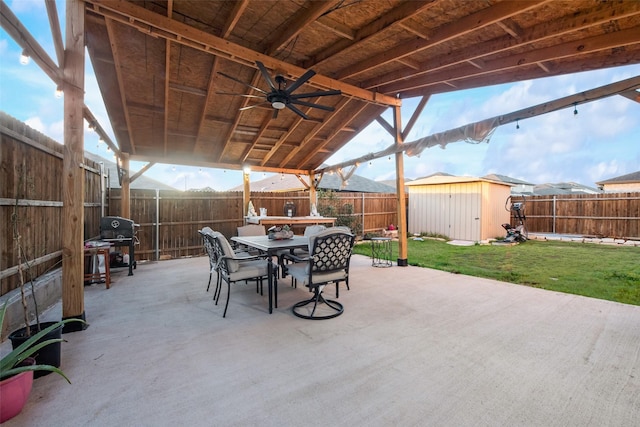 view of patio featuring ceiling fan, area for grilling, and a shed