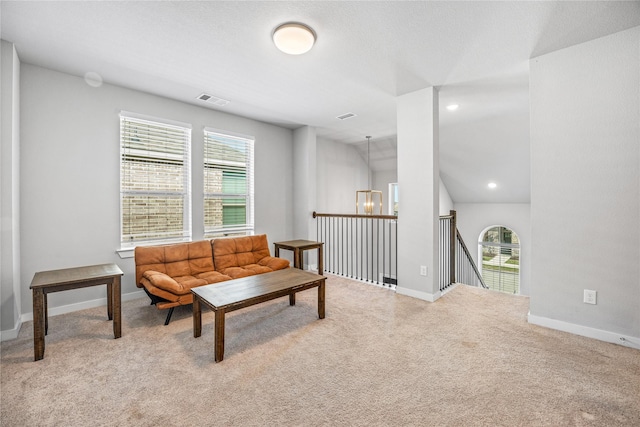 carpeted living room featuring lofted ceiling, a healthy amount of sunlight, and a chandelier