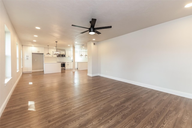 unfurnished living room featuring dark hardwood / wood-style floors and ceiling fan