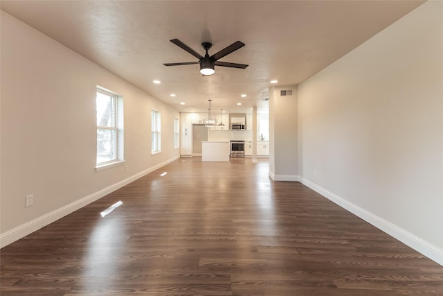 unfurnished living room with ceiling fan and dark hardwood / wood-style flooring