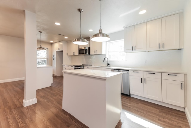 kitchen featuring a kitchen island, white cabinetry, appliances with stainless steel finishes, and pendant lighting