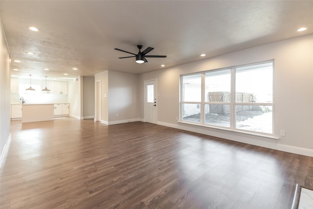 unfurnished living room with ceiling fan, dark hardwood / wood-style floors, and sink