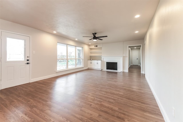 unfurnished living room with dark wood-type flooring and ceiling fan