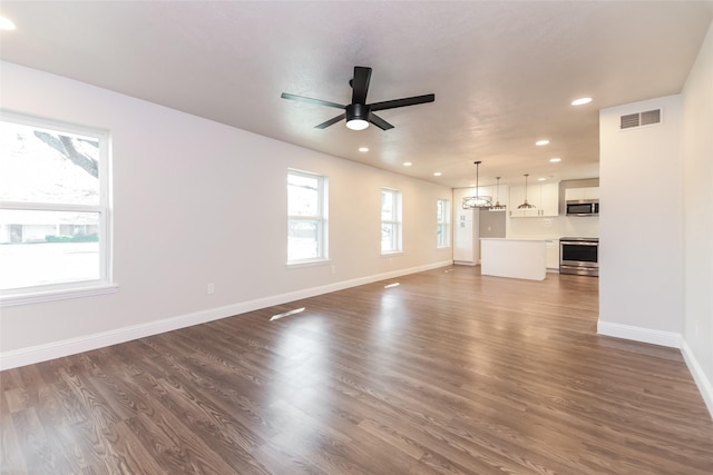 unfurnished living room featuring dark hardwood / wood-style floors and ceiling fan