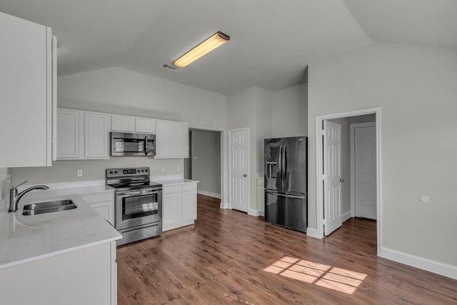 kitchen featuring lofted ceiling, appliances with stainless steel finishes, sink, and white cabinets