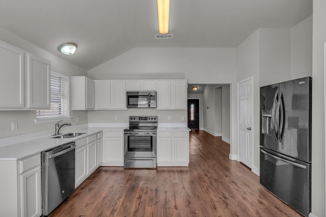 kitchen featuring lofted ceiling, sink, appliances with stainless steel finishes, white cabinetry, and dark hardwood / wood-style flooring