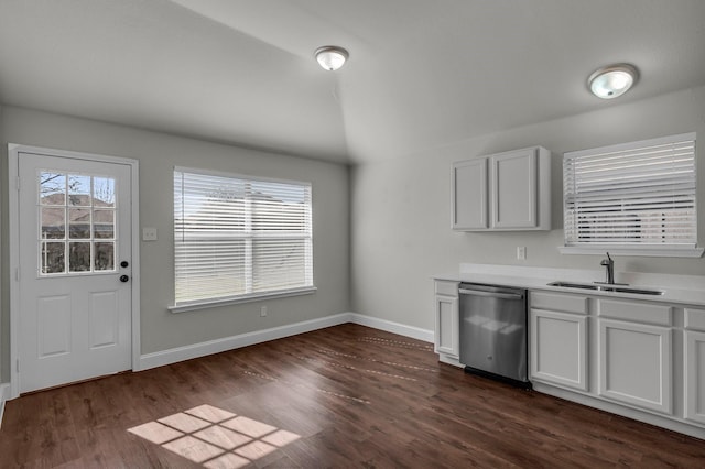 kitchen with white cabinetry, dishwasher, vaulted ceiling, and sink