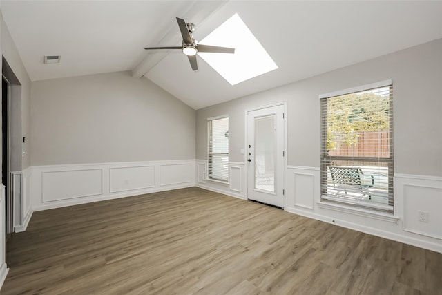 interior space featuring hardwood / wood-style flooring, lofted ceiling with skylight, a wealth of natural light, and ceiling fan