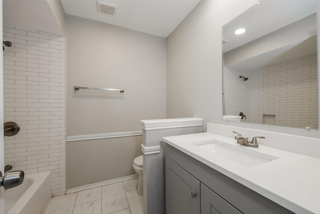 full bathroom with vanity, tiled shower / bath, and toilet