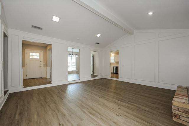 unfurnished living room featuring hardwood / wood-style flooring and lofted ceiling with beams