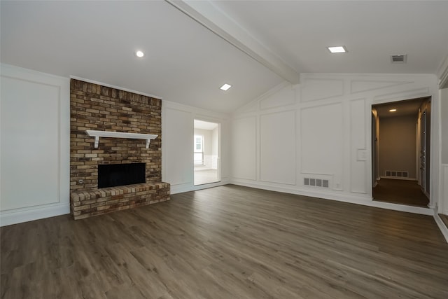 unfurnished living room featuring dark hardwood / wood-style flooring, vaulted ceiling with beams, and a brick fireplace