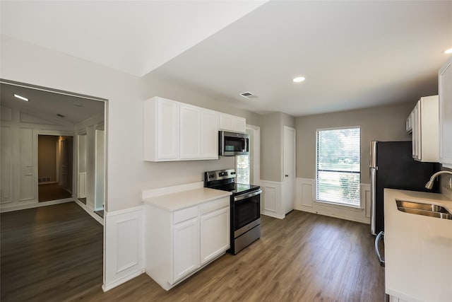 kitchen featuring dark wood-type flooring, stainless steel appliances, sink, and white cabinets