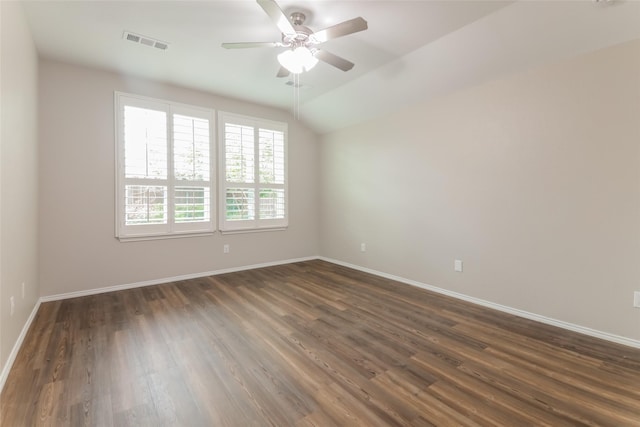 empty room featuring ceiling fan, vaulted ceiling, and dark hardwood / wood-style flooring