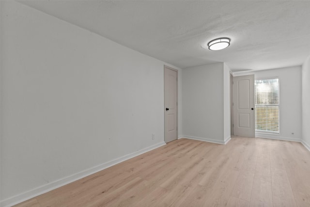 empty room with a textured ceiling and light wood-type flooring